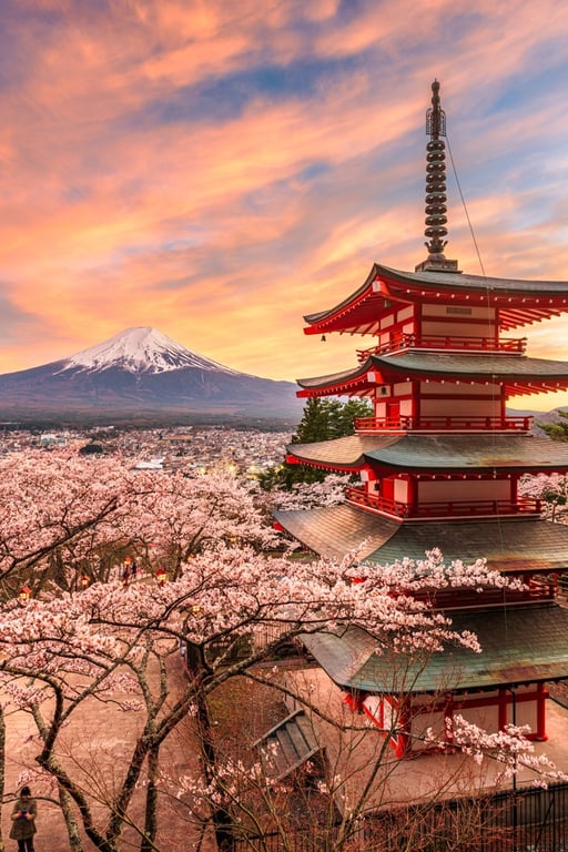 Mt. Fuji and pagoda as seen from Fujiyoshida, Japan during spring season with cherry blossoms.